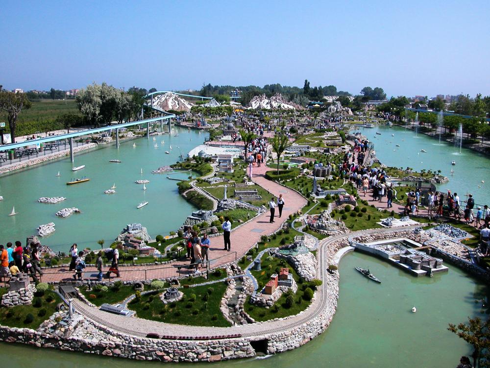 Miniature park with models and visitors along the pathways.