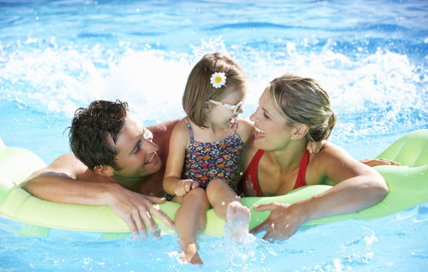 Famiglia felice in piscina su un materassino gonfiabile.